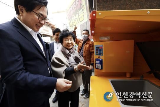 박일하 구청장이 지난 3월 관내 한 빌라에 최초 설치된 ‘음식물류폐기물 RFID(전자태그) 종량기’를 주민들과 시연하고 있다.