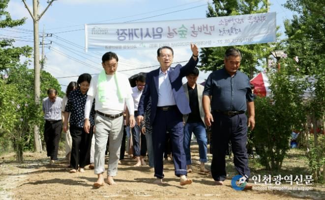 송인헌 군수와 참석자들이 성황천 맨발숲길 임시 개장식 후 맨발로 숲길을 걸으며 개장을 기념하고 있다