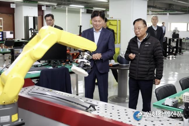 ㈜에이엘로봇의 강대희 대표가 조용익 부천시장에게 로봇팔을 이용한 연마공정을 시연하고 있다.