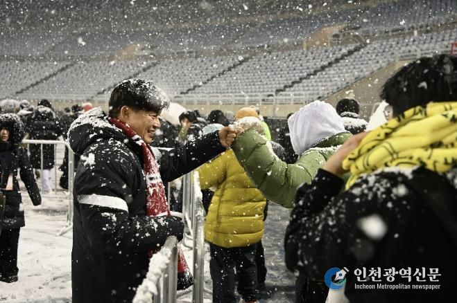 부천FC1995의 승강 PO 1차전이 폭설로 연기된 후 돌아가는 시민들과 조용익 부천시장이 주먹인사를 나누고 있다.