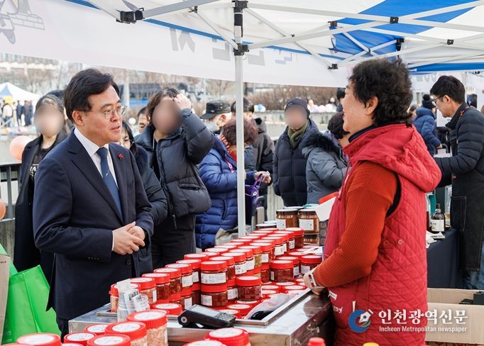 진교훈 강서구청장(왼쪽)이 5일 마곡광장에서 열린 ‘설맞이 농특산물 직거래장터’를 찾아 상인과 대화를 나누고 있다.
