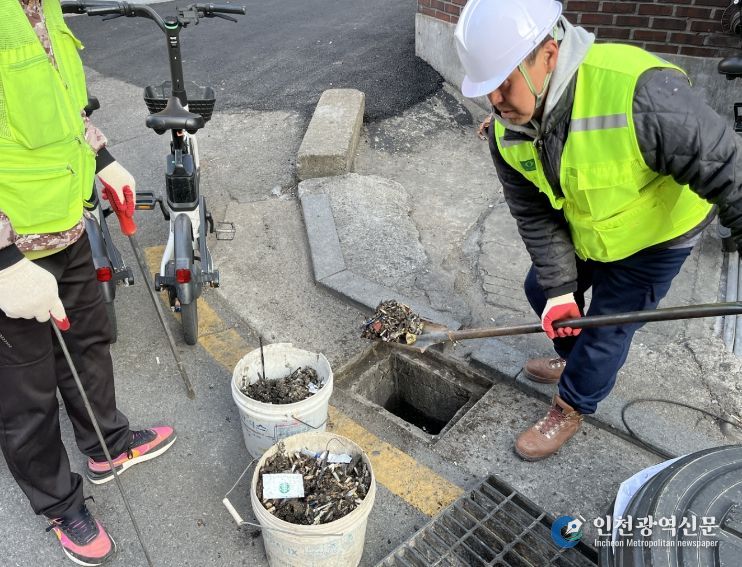 성북구가 장마철 침수 피해 예방을 위해 빗물받이 대청소와 점검을 실시하는 가운데, 작업자들이 빗물받이 내부 이물질을 제거하고 준설 차량을 활용해 배수 상태를 점검하고 있다.