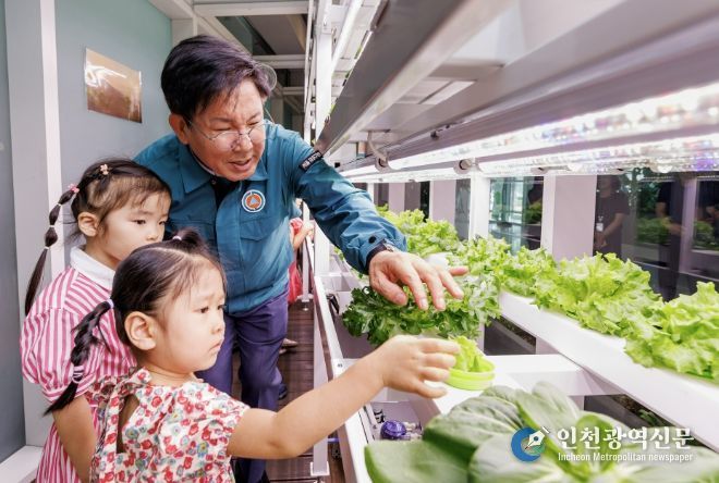 박강수 마포구청장과 어린이들이 청사 내 스마트팜 채소를 관찰하고 있다