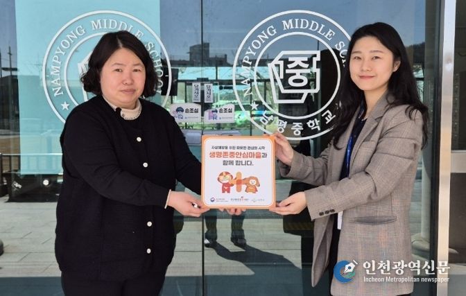 나주시보건소가 남평중학교에 생명 존중 안심마을 현판을 전달하고 있다.